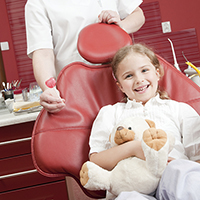 Young girl in dentist chair with lollipop