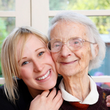 Woman and elder mother smiling together