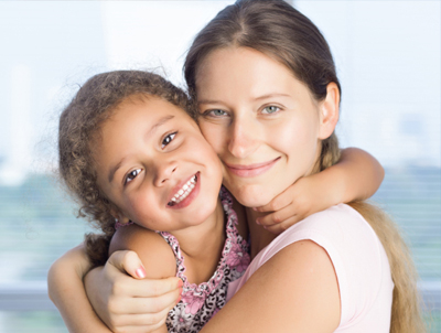 Woman and daughter hugging and smiling