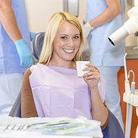 Woman in dental chair with swish cup