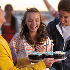 Smiling teen with birthday cupcakes