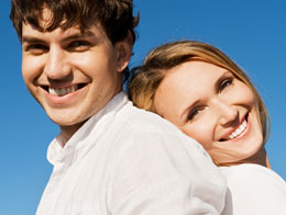 Couple standing back to back and smiling